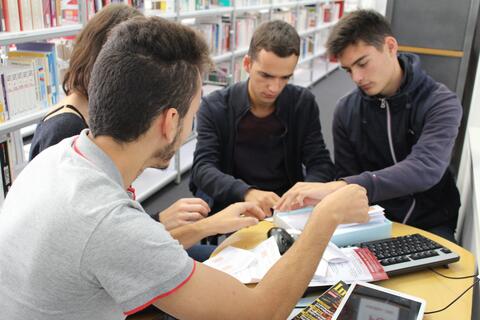Étudiants participant au jeu de piste Des étudiants collaborent autours d'une table afin d'avancer dans le jeu de piste.