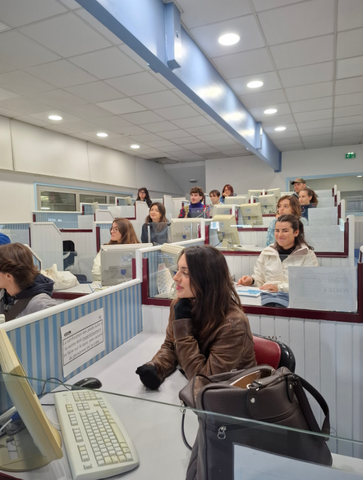 Les étudiantes et étudiants sont tous assis devant des bureaux individuels sur lesquels se trouvent un ordinateur et des feuilles. L'ordinateur leur servent à participer à la criée.